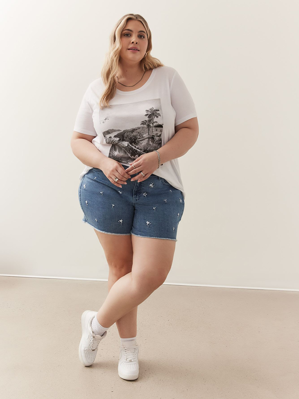 A model wearing embroidered floral denim shorts from Penningtons.
