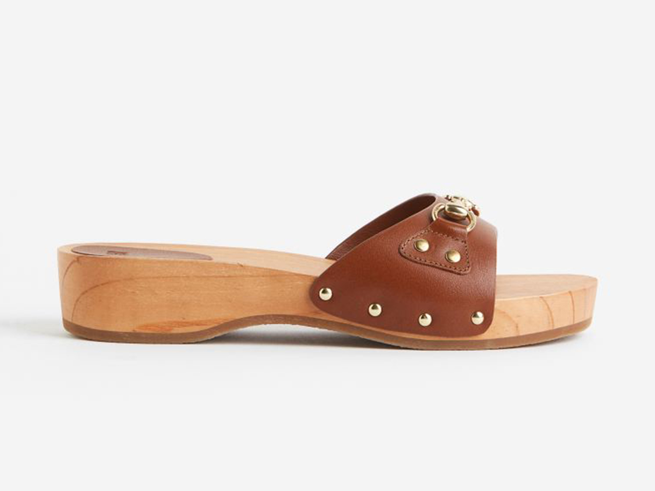 A side profile of a pair of flatform wood and leather clogs from H&M.