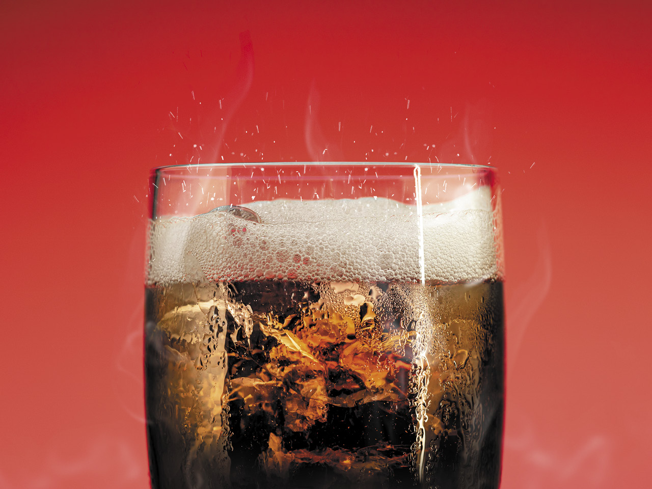 A glass of cola on a red background