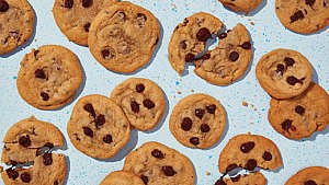 Pieces of chocolate chip cookies with a blue background.