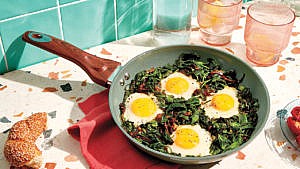 Nargesi-e Esfanaj, an Iranian/Persian egg dish, served in a frying pan on a speckled kitchen counter