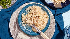 A blue bowl filled with Classic Parmesan Risotto.