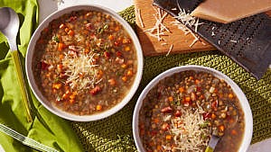 Two bowl of Italian style lentil soup decorated with parmesan cheese.