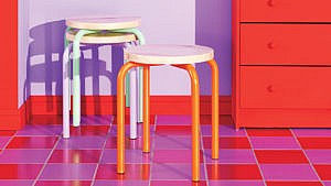 Decorating with colour: Three colourful Ikea stools on red and purple checkered tiles.