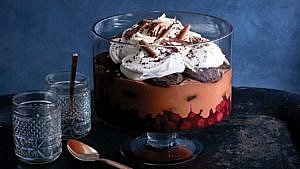 a Black Forest trifle in a glass trifle bowl topped with whipped cream, Black Forest trifle recipe, Christmas and holiday trifle and pudding recipes
