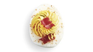 Classic devilled eggs in a small white plate with white background.
